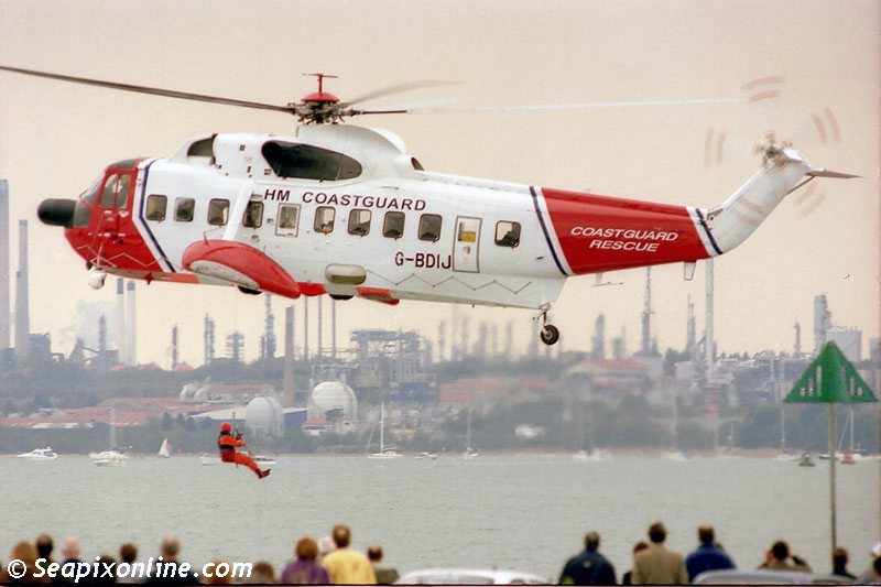 A UK Coastguard Sikorsky S-61N MkII air-sea rescue helicopter lowers a crew member to the deck of a vessel during a public display at Southampton, England. 1997. Photo by SeapixOnline.com/Trevor Coppock